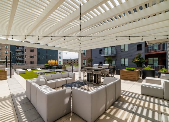 a lounge area with white couches and tables under a white roof at EagleRidge Plaza Residences, Fargo, North Dakota