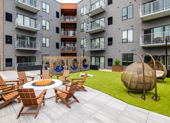 an outdoor patio with chairs and a fire pit at an apartment building at EagleRidge Plaza Residences, Fargo, 58104