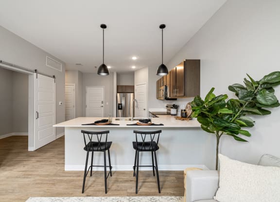 a kitchen with a white counter top and two black stools at EagleRidge Plaza Residences, Fargo, ND, 58104