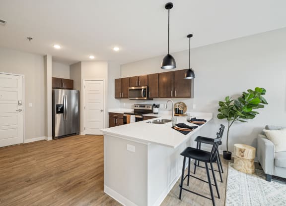 a kitchen with a white island and a stainless steel refrigerator at EagleRidge Plaza Residences, Fargo, 58104