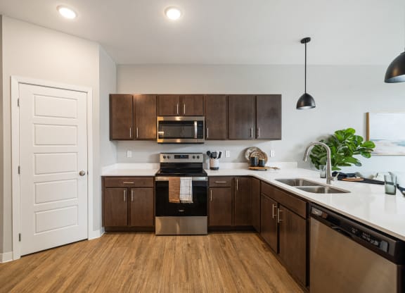 a kitchen with wooden cabinets and stainless steel appliances and a door at EagleRidge Plaza Residences, Fargo, North Dakota