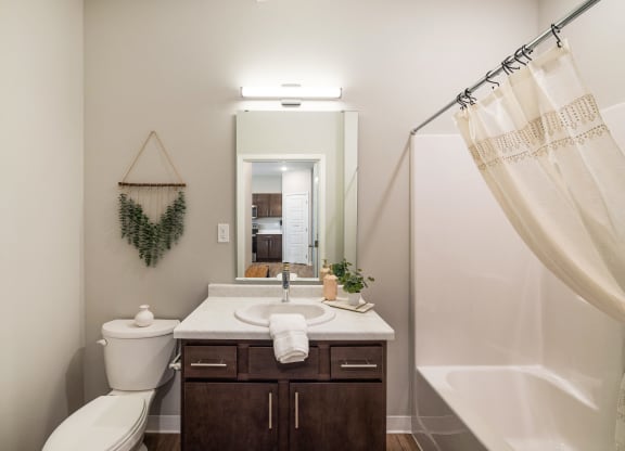 a bathroom with a toilet sink and shower and a mirror at EagleRidge Plaza Residences, Fargo, ND, 58104