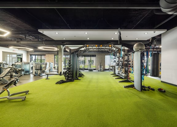 a gym with a green carpet and weights and exercise equipment at EagleRidge Plaza Residences, Fargo, ND, 58104