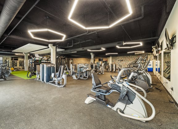 a gym with exercise equipment and lights on the ceiling at EagleRidge Plaza Residences, Fargo