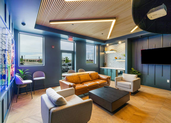 a lobby with couches and chairs and a tv at EagleRidge Plaza Residences, Fargo