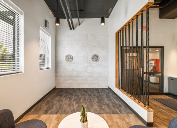 a room with a table and chairs and a wall with a screen at EagleRidge Plaza Residences, Fargo