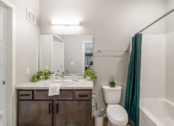 a bathroom with a shower toilet and sink and a mirror at EagleRidge Plaza Residences, Fargo, North Dakota