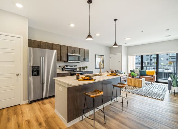 a kitchen with a large island and a stainless steel refrigerator at EagleRidge Plaza Residences, Fargo, ND, 58104