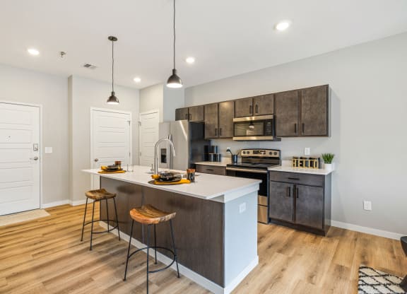 an open kitchen with a large island with three stools at EagleRidge Plaza Residences, North Dakota, 58104