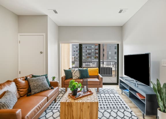 a living room with a leather couch and a television at EagleRidge Plaza Residences, Fargo, North Dakota