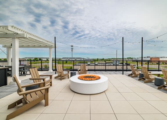 the terrace of a building with chairs and a fire pit at The Standard on 32nd, West Fargo, 58078