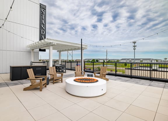 a patio with a fire pit and chairs on top of a building at The Standard on 32nd, North Dakota