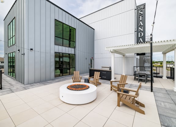 a patio with a fire pit and chairs outside of a building at The Standard on 32nd, West Fargo, ND
