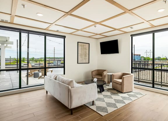 a living room with couches and chairs and large windows at The Standard on 32nd, West Fargo, ND