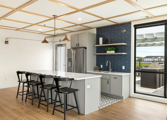 a kitchen with a white counter top and black bar stools at The Standard on 32nd, West Fargo