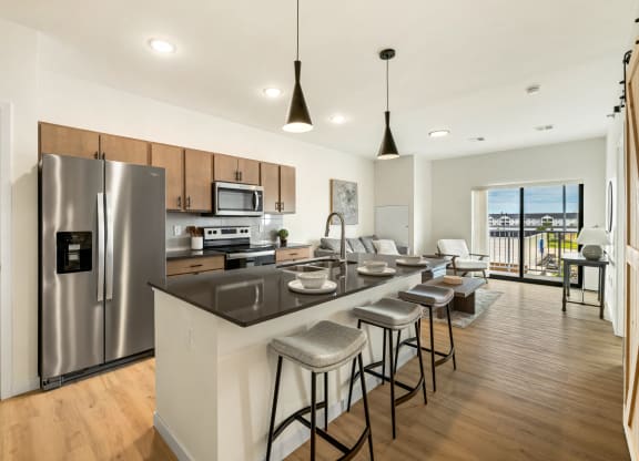 a kitchen with a large island and a stainless steel refrigerator at The Standard on 32nd, West Fargo, North Dakota