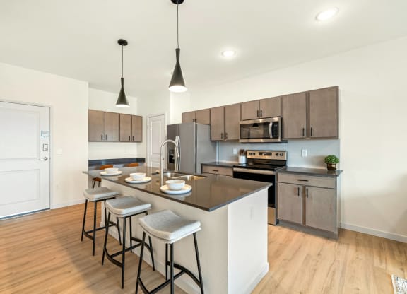 an open kitchen with a large island with three stools at The Standard on 32nd, North Dakota