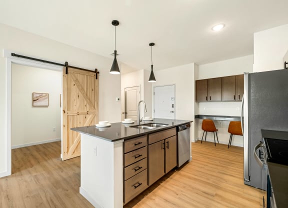 a kitchen with a large island and a sliding barn door at The Standard on 32nd, West Fargo