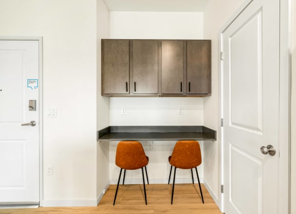 a kitchen with two chairs and a counter with cabinets at The Standard on 32nd, West Fargo, North Dakota