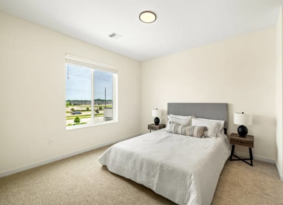a bedroom with a large bed and a window at The Standard on 32nd, West Fargo, ND, 58078