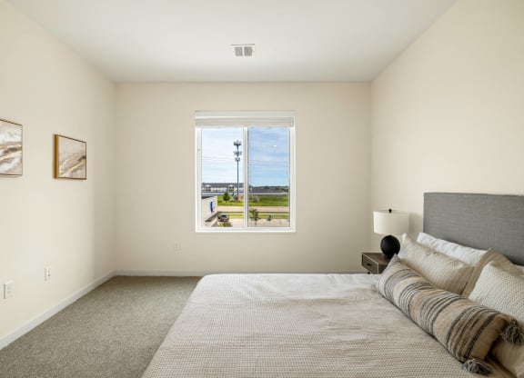 a bedroom with a large bed and a window at The Standard on 32nd, West Fargo, North Dakota