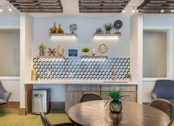 a room with a table and chairs and a bar in the back at Northern Lights a Lifestyle-Driven Community, West Fargo, ND, 58078