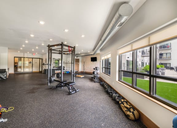 a gym with weights and other equipment and large windowsat Northern Lights a Lifestyle-Driven Community, North Dakota