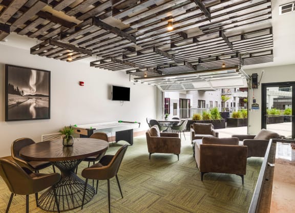 a lounge area with tables chairs and chairs and a televisionat Northern Lights a Lifestyle-Driven Community, West Fargo, 58078