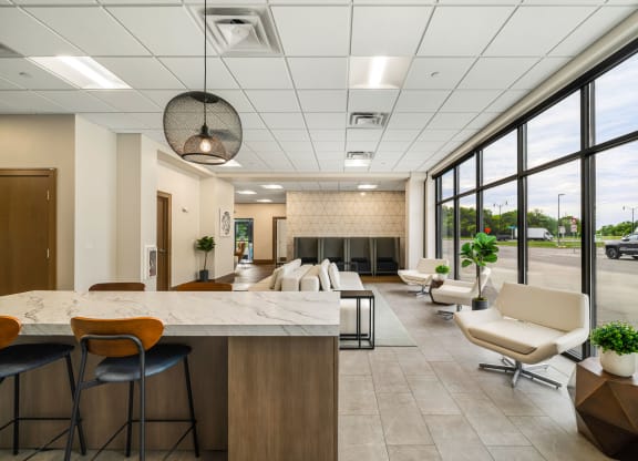 a lobby with a table and chairs and a fireplaceat Northern Lights a Lifestyle-Driven Community, West Fargo, North Dakota