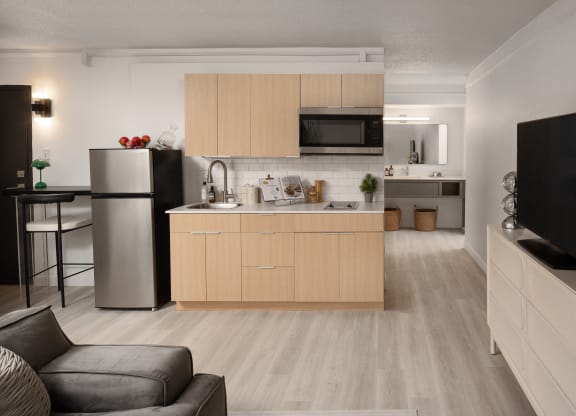 a kitchen and living room with a refrigerator and a sink at Vision on Lombard, Baltimore, MD 21201
