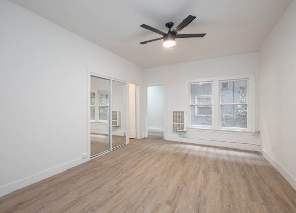 A room with a ceiling fan and a window at Westmore Manor Apartments, Los Angeles, CA