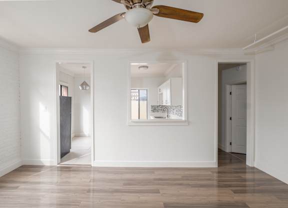 A room with a ceiling fan and wooden floors at Mariposa Willows Apartments, California