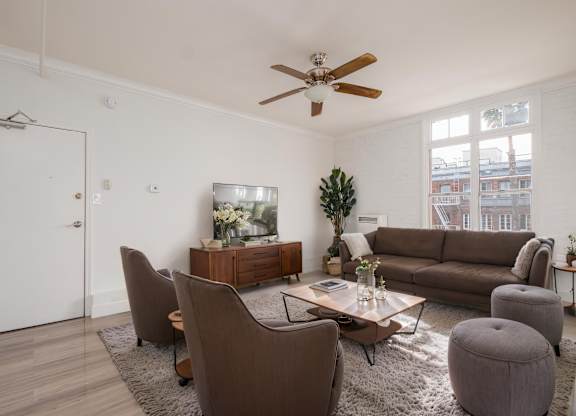 A living room with brown furniture and a ceiling fan at Mariposa Willows Apartments, Los Angeles, CA, 90004