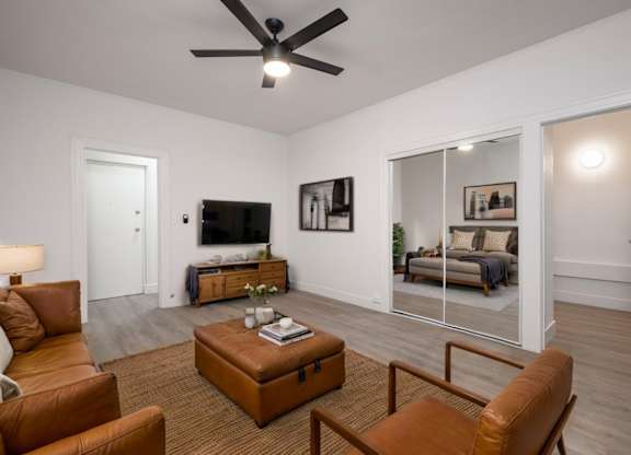 A living room with a brown leather chair and a brown ottoman at Westmore Manor Apartments, Los Angeles, CA, 90020