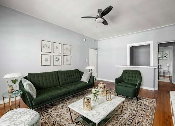 A living room with a green couch and a white coffee table.at Normandie Summit Apartments, California 90004