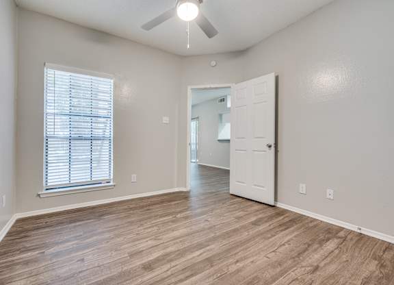 an empty living room with a white door and a ceiling fan at Foxborough Apartments, Irving, TX, Texas, 75061