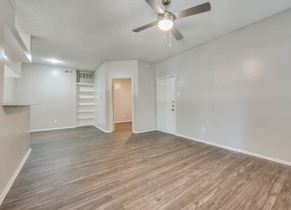an empty living room with wood flooring and a ceiling fan at Foxborough Apartments, Irving, TX, Texas, 75061