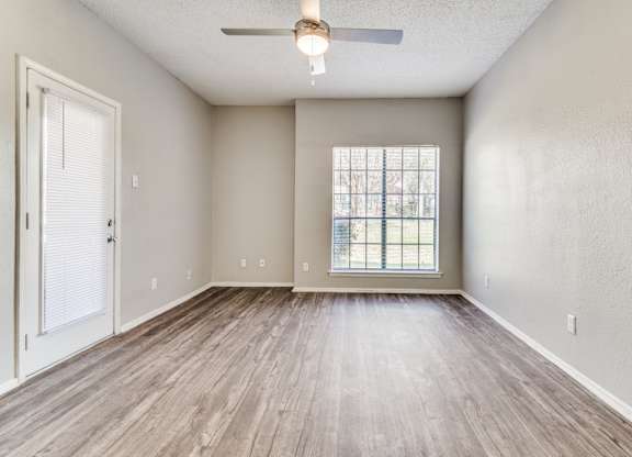 an empty living room with a ceiling fan at Foxborough Apartments, Irving, TX, Texas