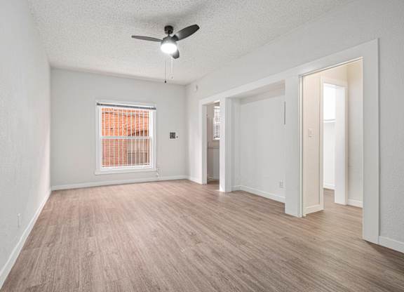 A room with a ceiling fan and a window with orange blinds at Hillstone Flats Apartments, Los Angeles, CA