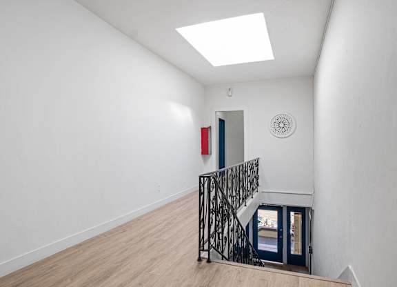 A white room with a skylight and a black metal staircase at Hillstone Flats Apartments, Los Angeles, CA