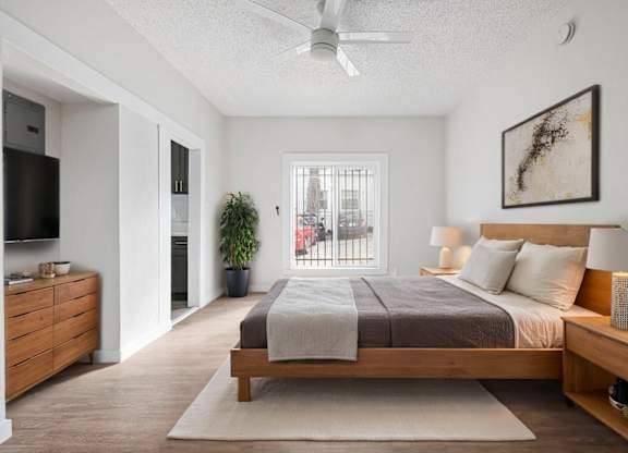 A bedroom with a bed, nightstand, and a ceiling fan at Hillstone Flats Apartments, Los Angeles, CA