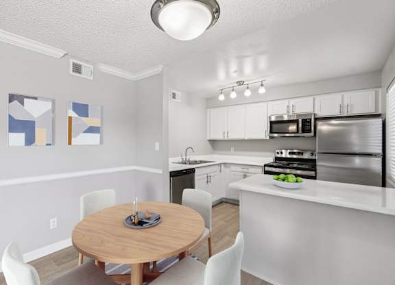 A kitchen with a table and chairs in the middle of the room.