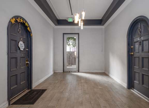 A hallway with a door on the right and a door on the left with a star on the top at Mariposa Willows Apartments, Los Angeles, 90004