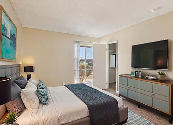 A bedroom with a bed, nightstand, and a television.