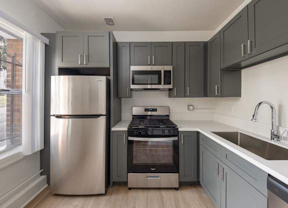 A modern kitchen with a stainless steel refrigerator and a built-in oven at Kenmore Park Apartments, California 90004