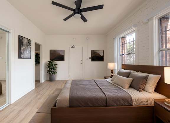 A bedroom with a large bed and a ceiling fan at Kenmore Park Apartments, Los Angeles, CA
