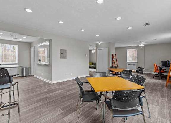a community room with tables and chairs and a kitchen at Hampton Gardens, Missouri, 63139