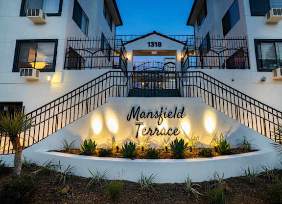 an image of the front entrance of the terrace apartment building at night