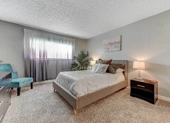 a bedroom with a bed and a dresser and a window t Desert Bay Apartments, Laughlin, NV