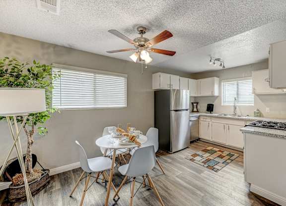 an open kitchen and dining room with a white table and chairs at Desert Bay Apartments, Laughlin, NV, 89029